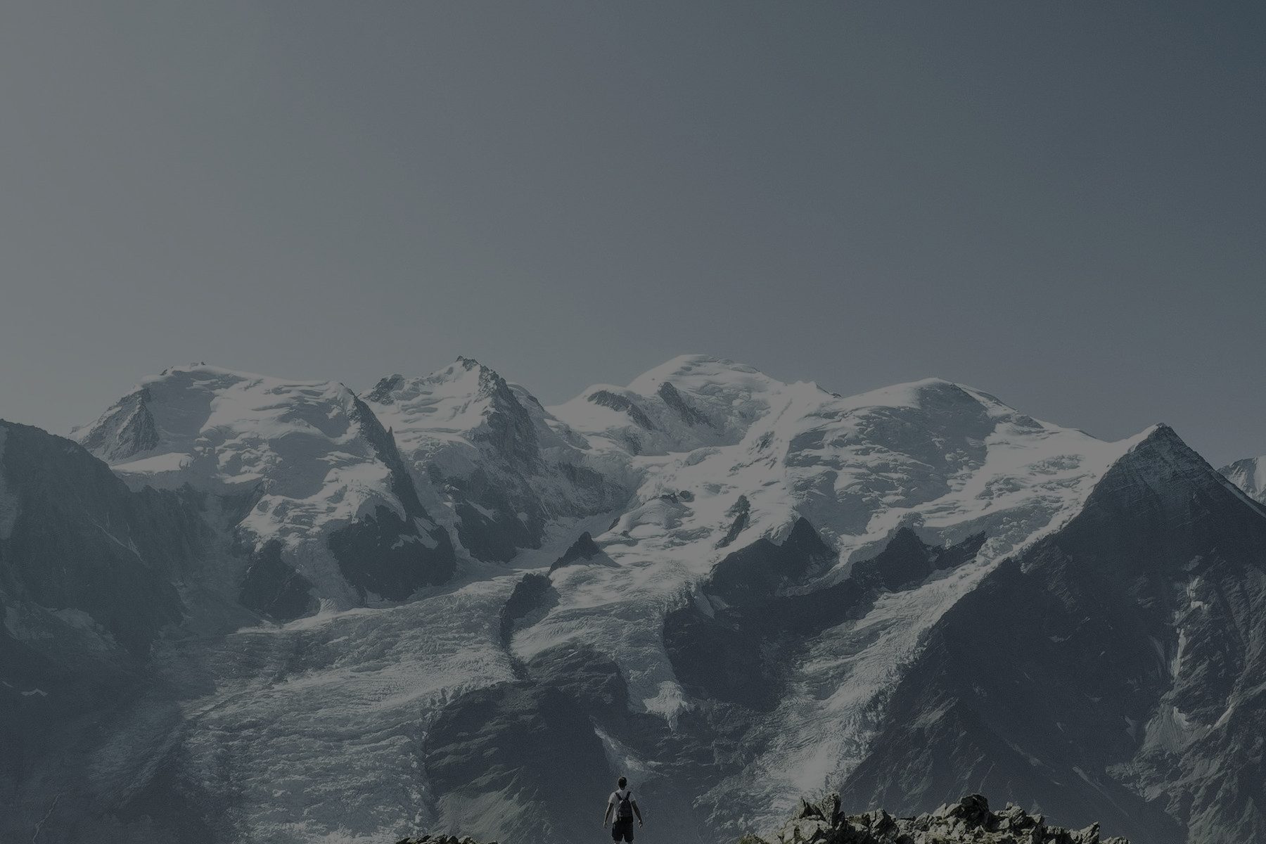 Wandelaar op een bergkam met de Mont Blanc op de achtergrond